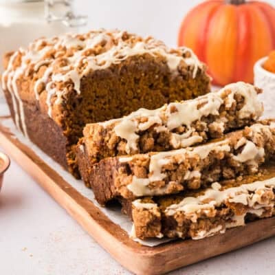 Sliced loaf of pumpkin streusel bread on cutting board.