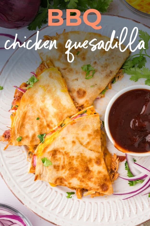 Plate full of BBQ chicken quesadilla wedges next to bbq sauce.