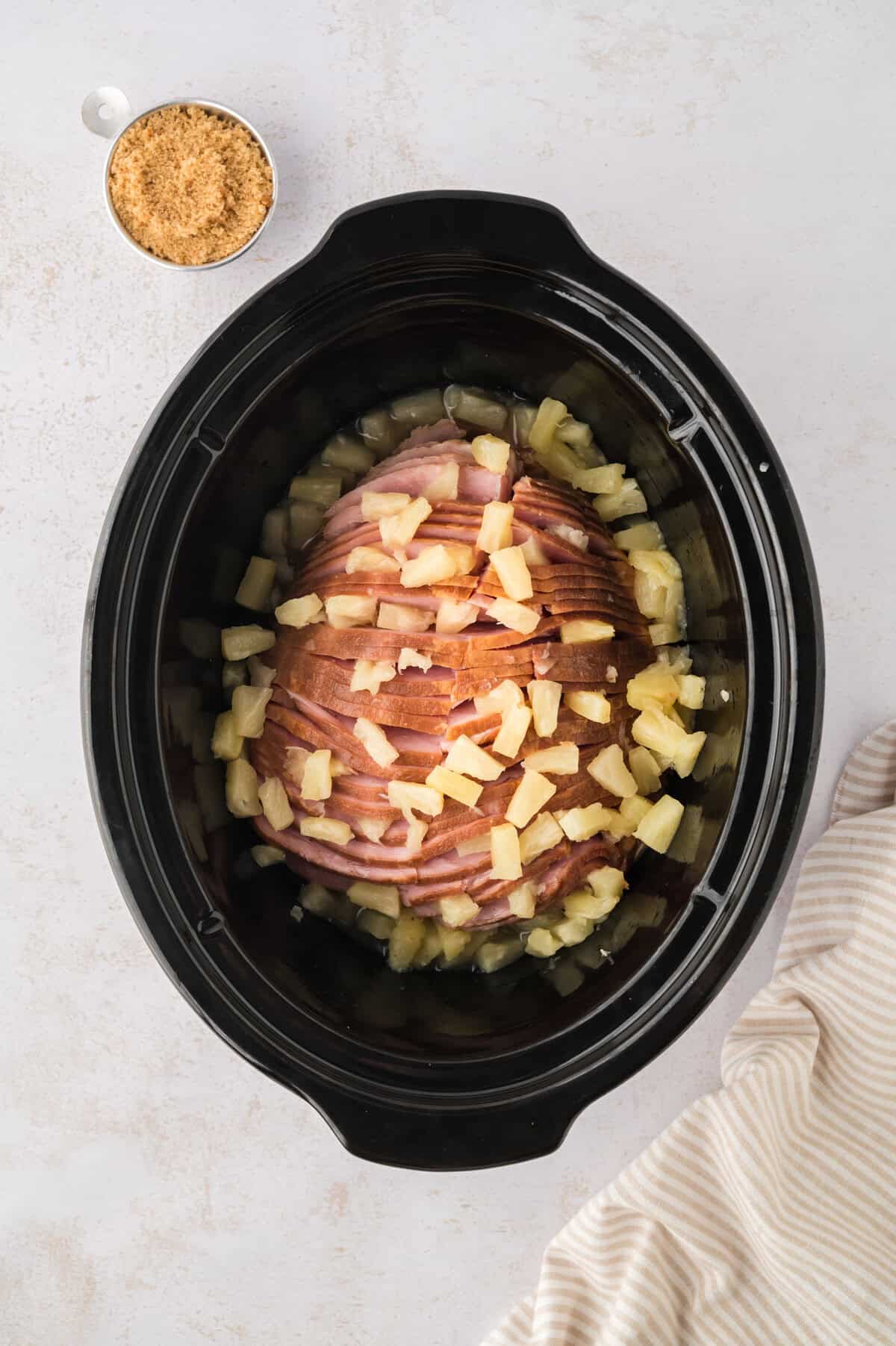 Ham topped with pineapple in crockpot.