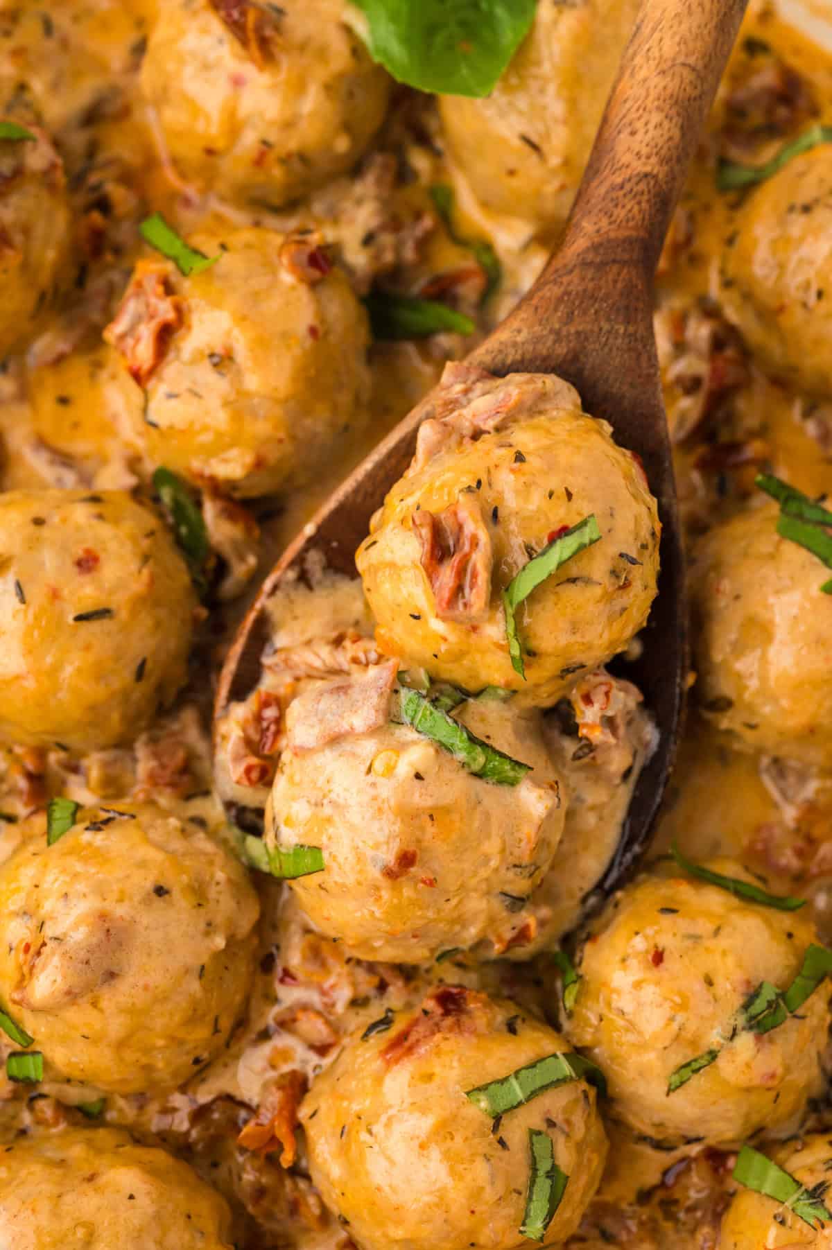 Marry me chicken meatballs on wooden spoon.