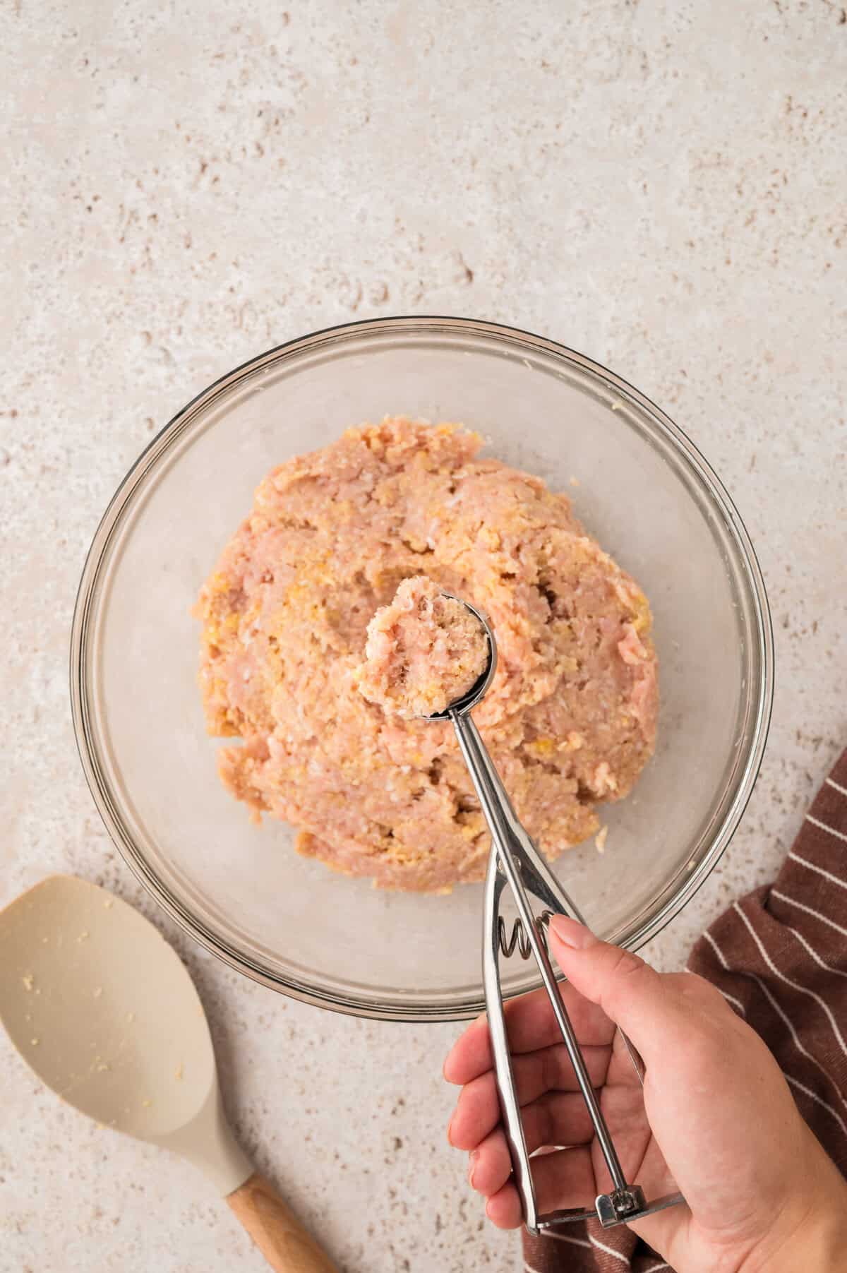 Ingredients for chicken meatballs in glass bowl.