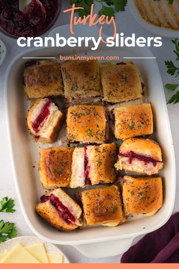 Leftover turkey sliders with cranberry sauce and cheese in baking dish.