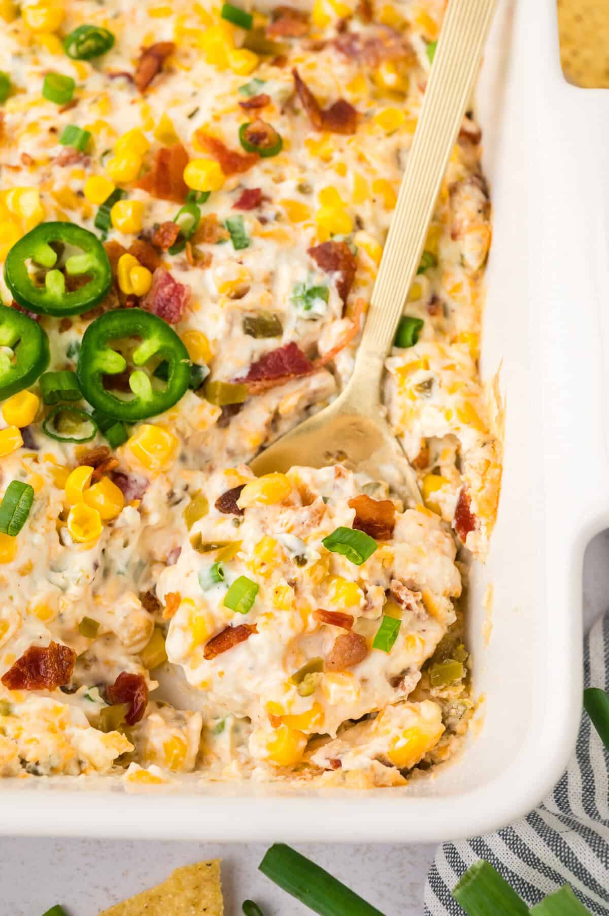 Crack corn dip in baking dish with spoon.