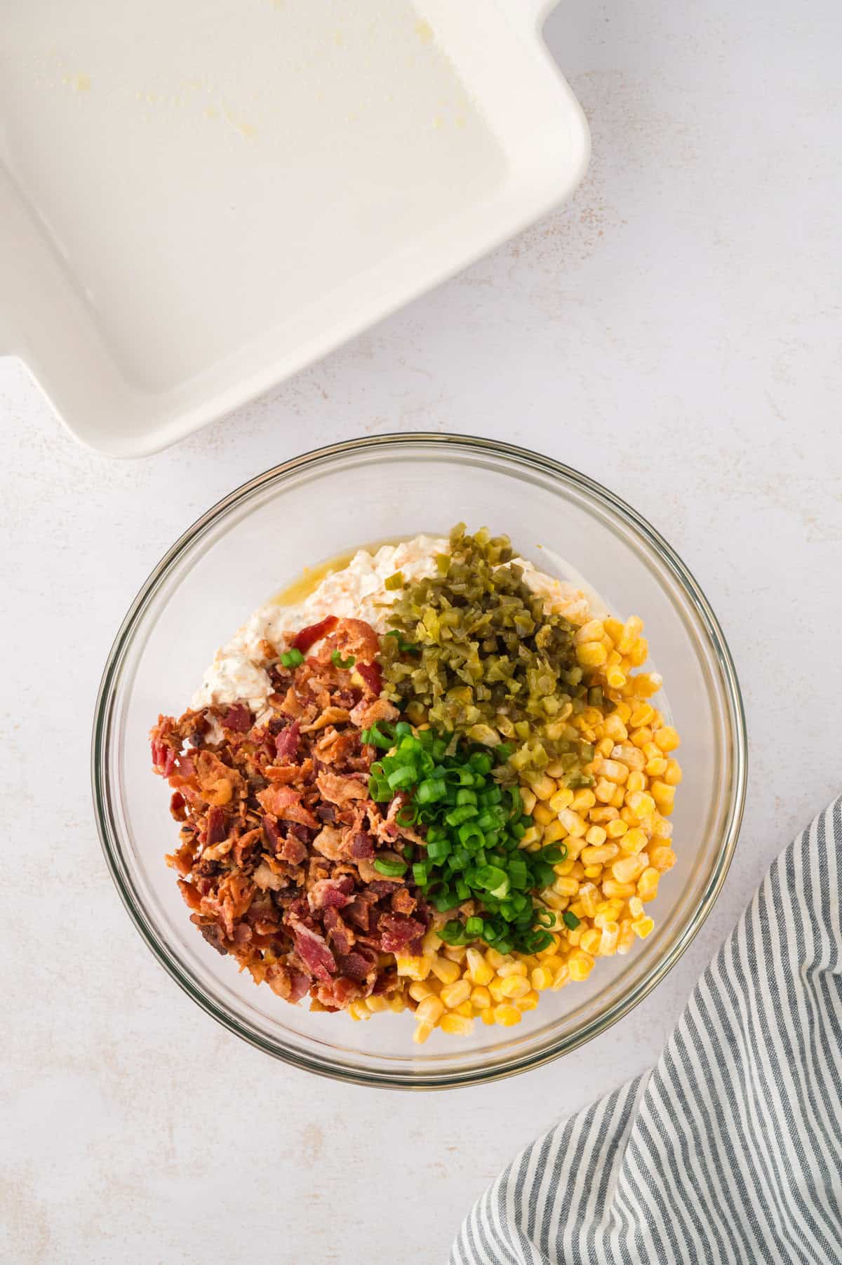 Bacon, jalapenos, and corn in mixing bowl with cheese.