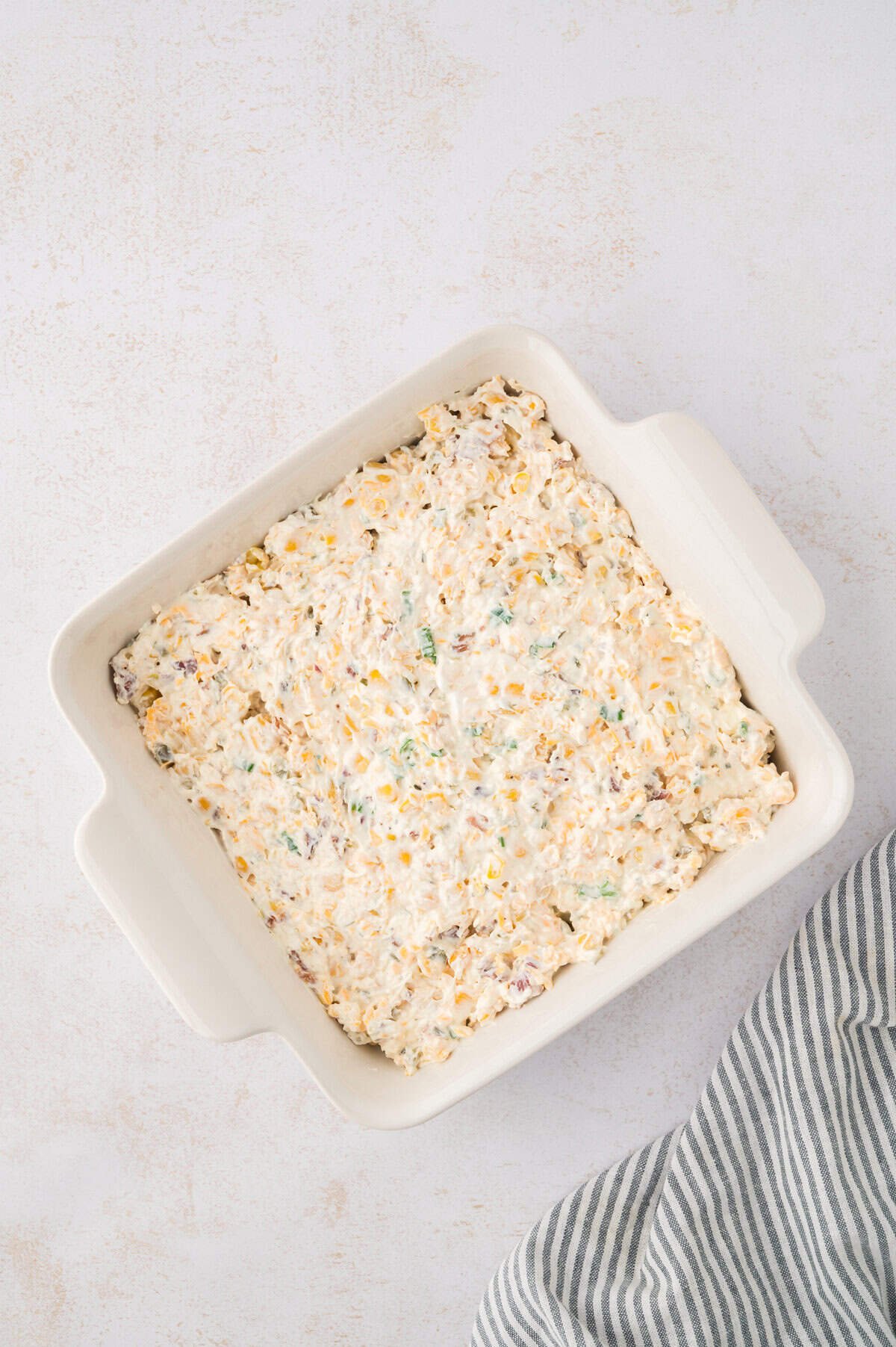 Cream cheese corn dip spread in baking dish.