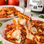 Plate full of crockpot ravioli on a fork.