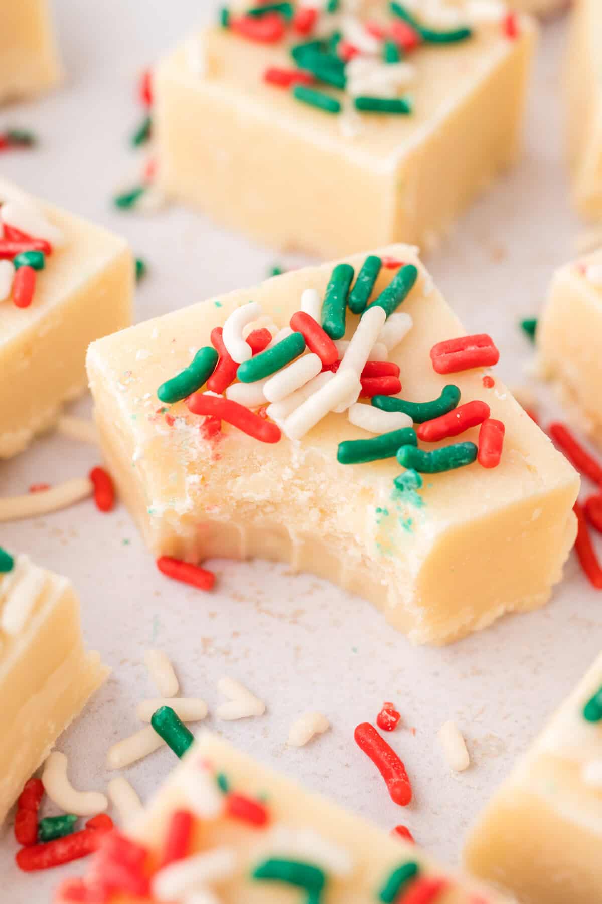 Bite taken out of a piece of sugar cookie fudge.