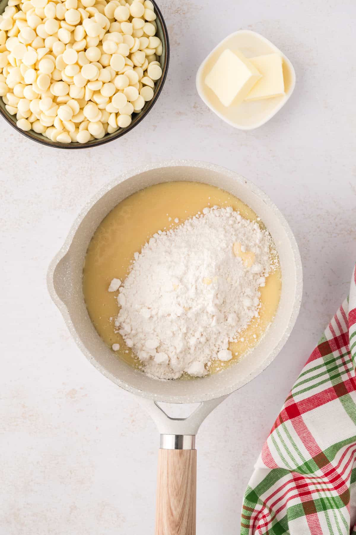 Sweetened condensed milk and sugar cookie mix in saucepan.