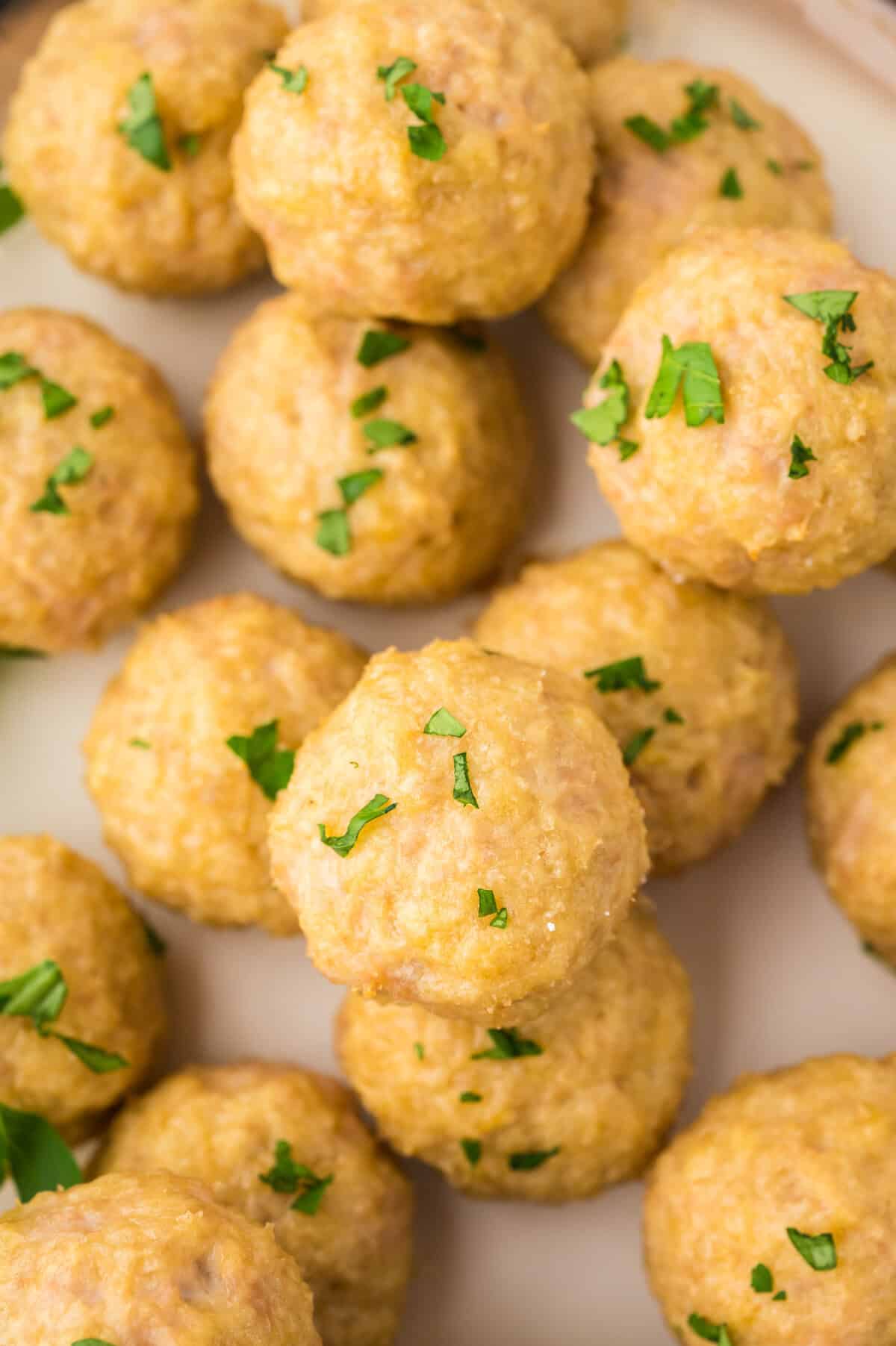 Pile of baked chicken meatballs on pan.