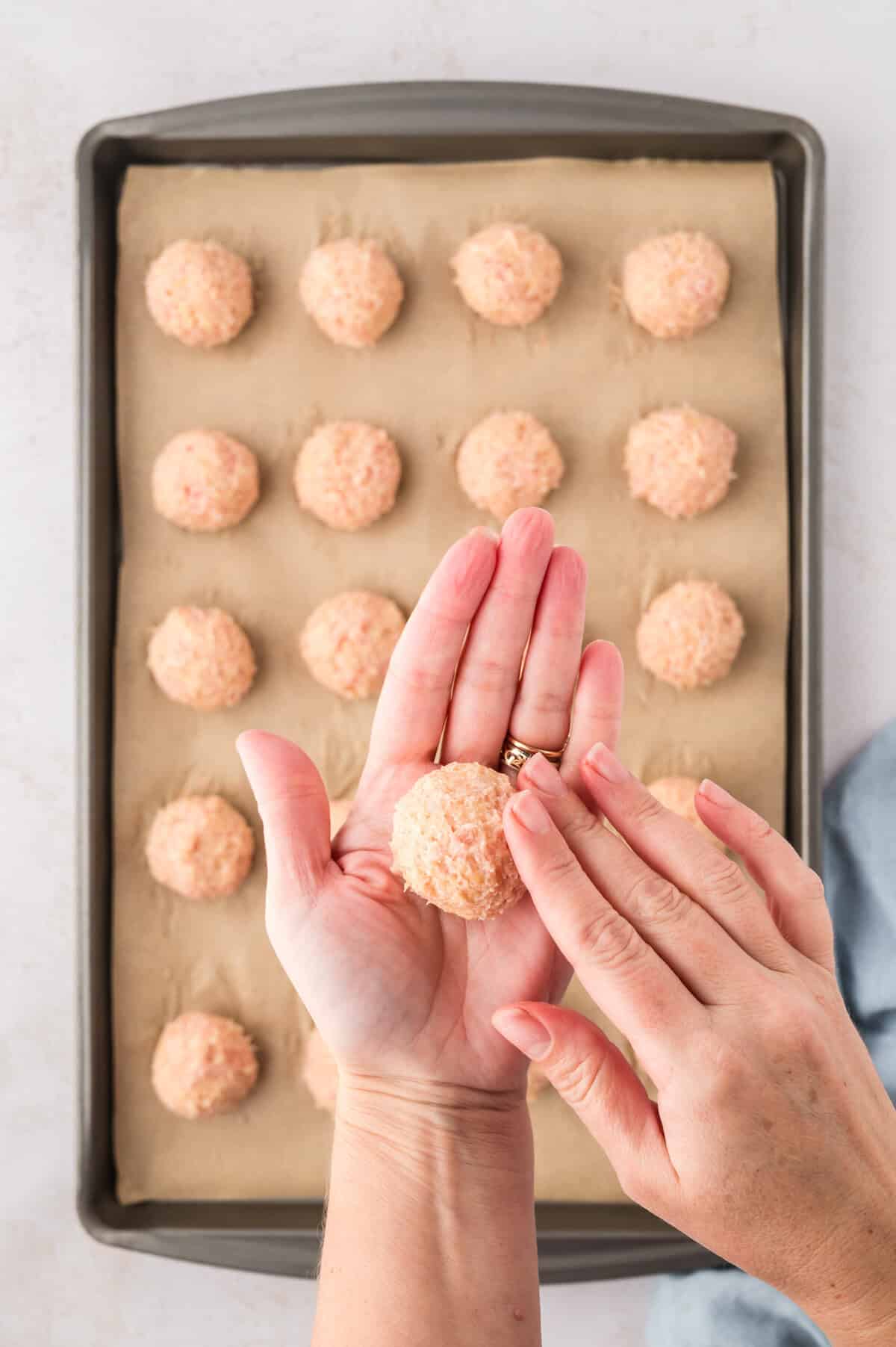 Meatballs being rolled into balls.