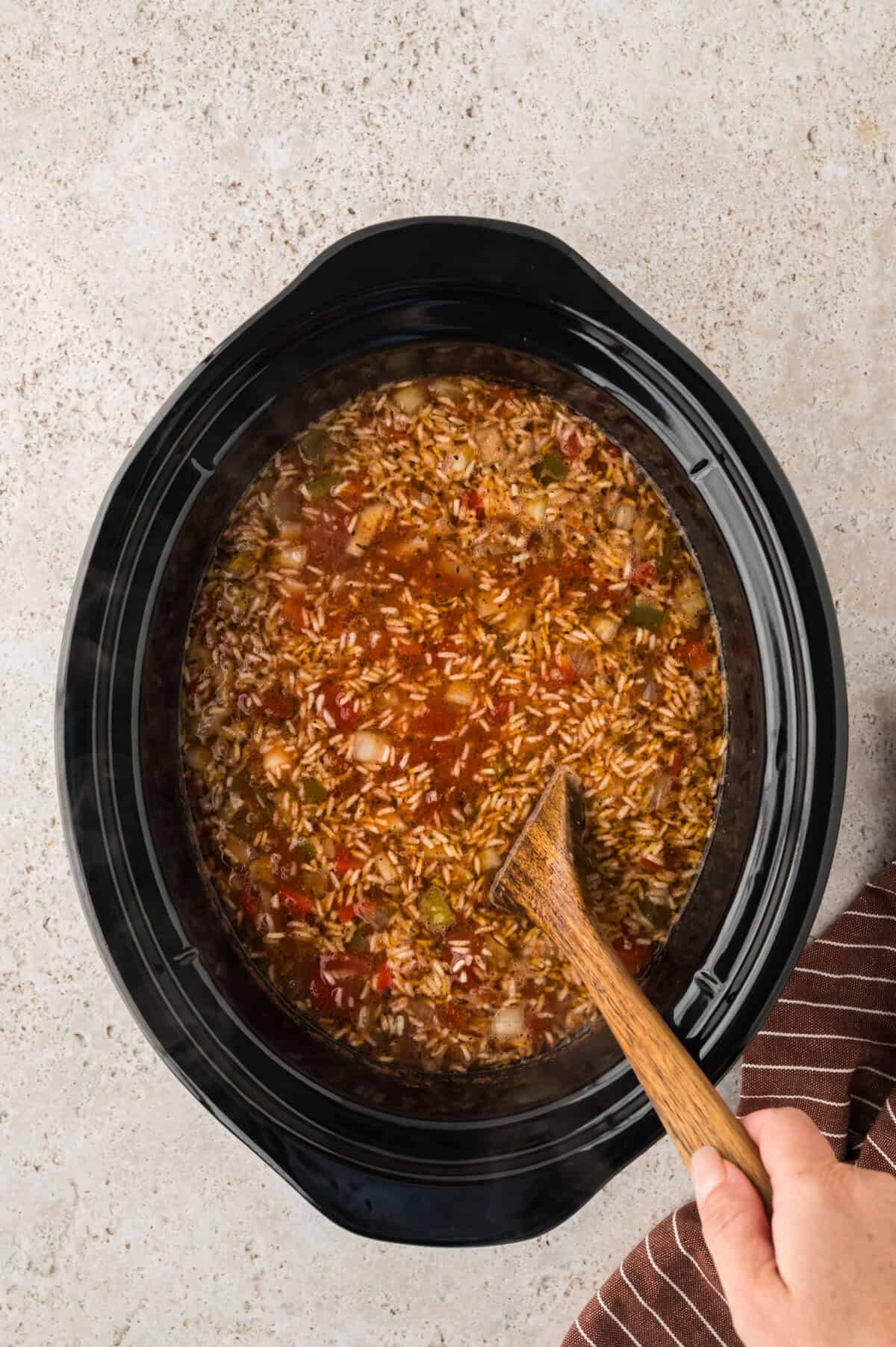 Crockpot stuffed pepper soup being stirred.