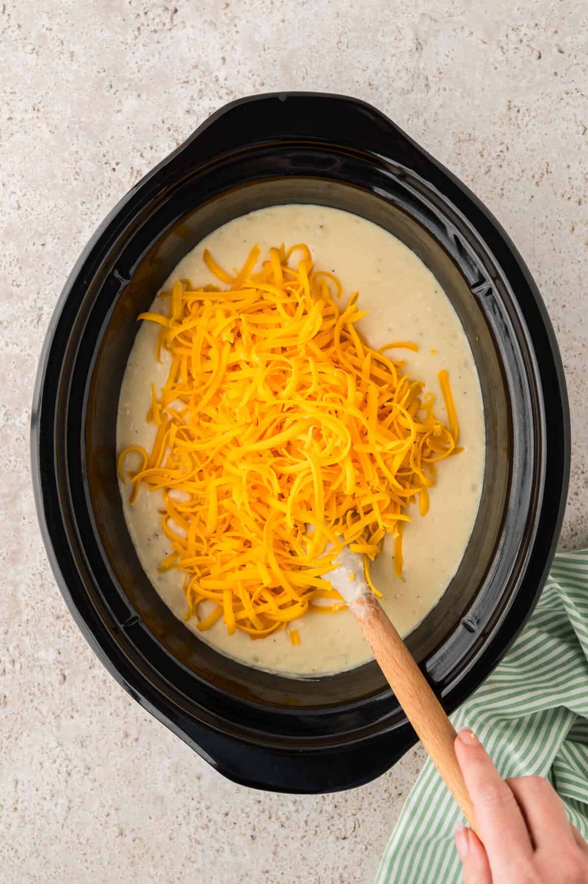 Cheese in slow cooker with potato soup.