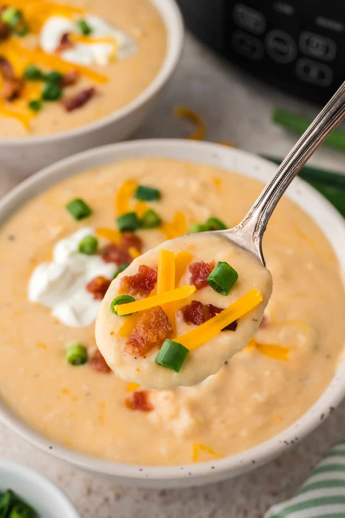 Spoonful of slow cooker potato soup made with hashbrowns.