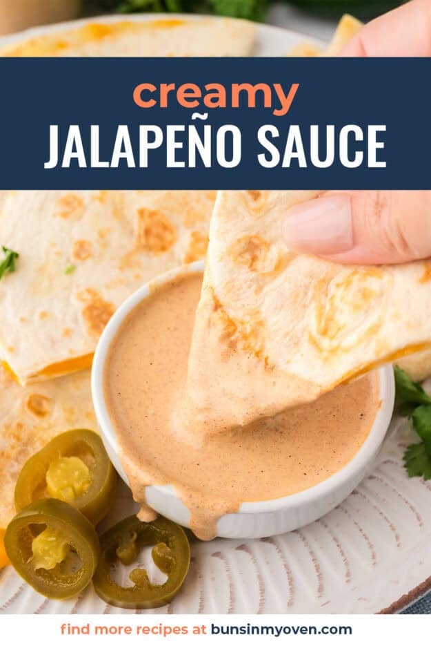 Hand dipping a quesadilla into copycat Taco Bell creamy jalapeno sauce.