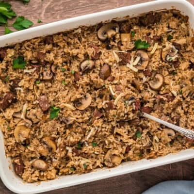 Baked rice casserole with steak and mushrooms in baking dish.