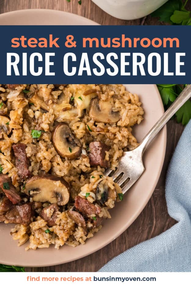 Plate full of baked rice with steak and mushrooms.