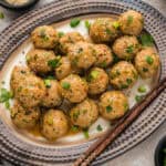 Baked chicken meatballs coated in sesame soy sauce on platter.