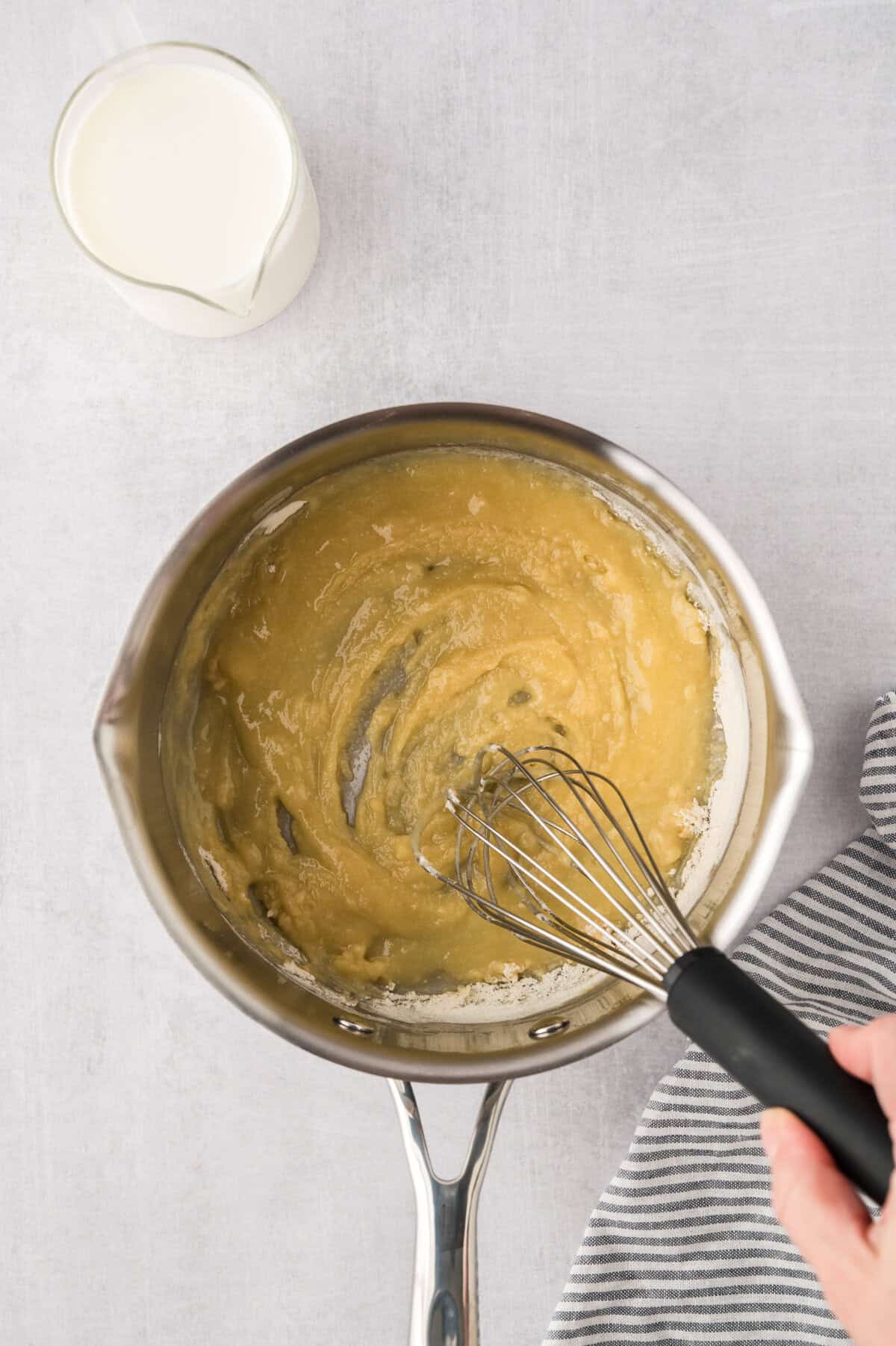 Whisking together a roux in a small sauce pan.