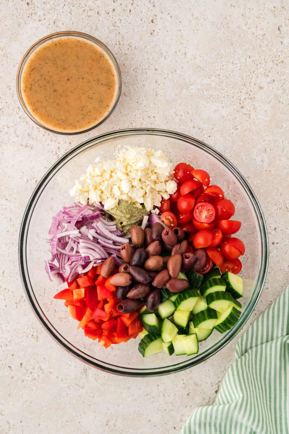 Ingredients for Greek cucumber salad in mixing bowl.