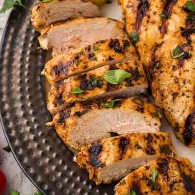 Sliced Mediterranean grilled chicken on platter.
