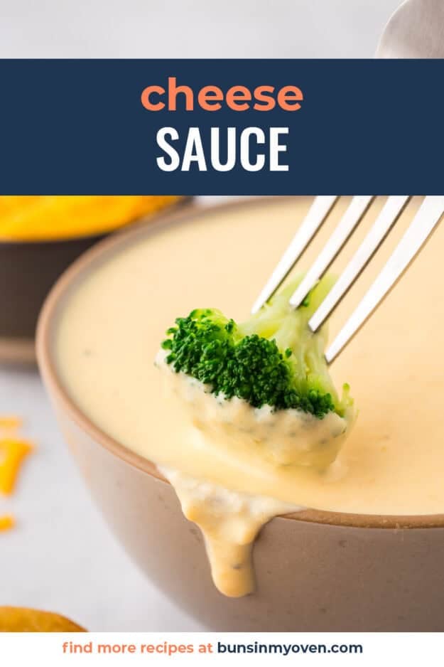 Piece of broccoli being dunked in homemade cheese sauce.