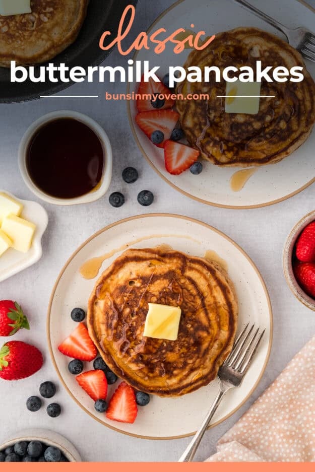 Stack of pancakes topped with butter on white plate.