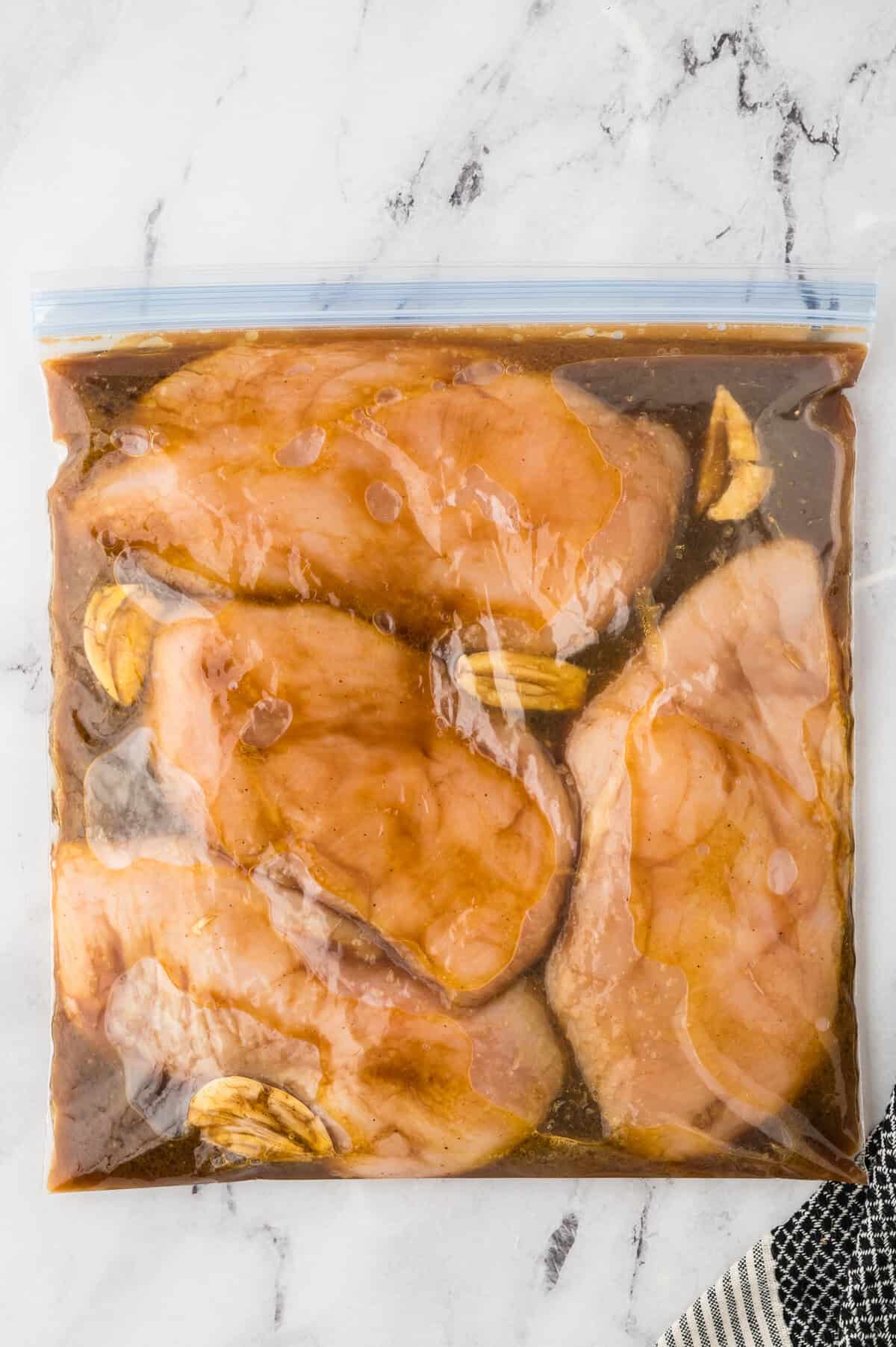 Chicken breast in ziptop bag with marinade.