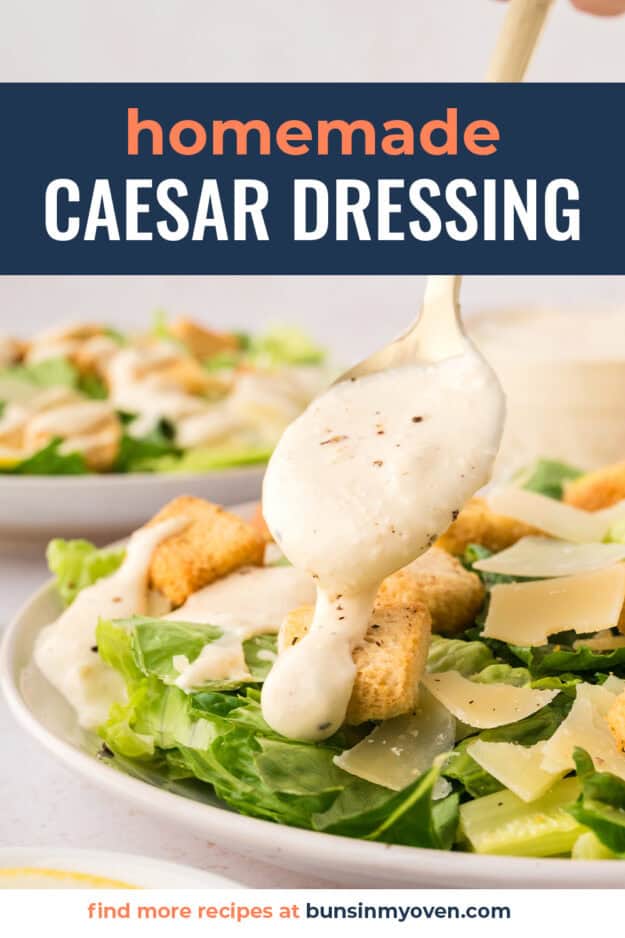 Caesar dressing being drizzled over salad.