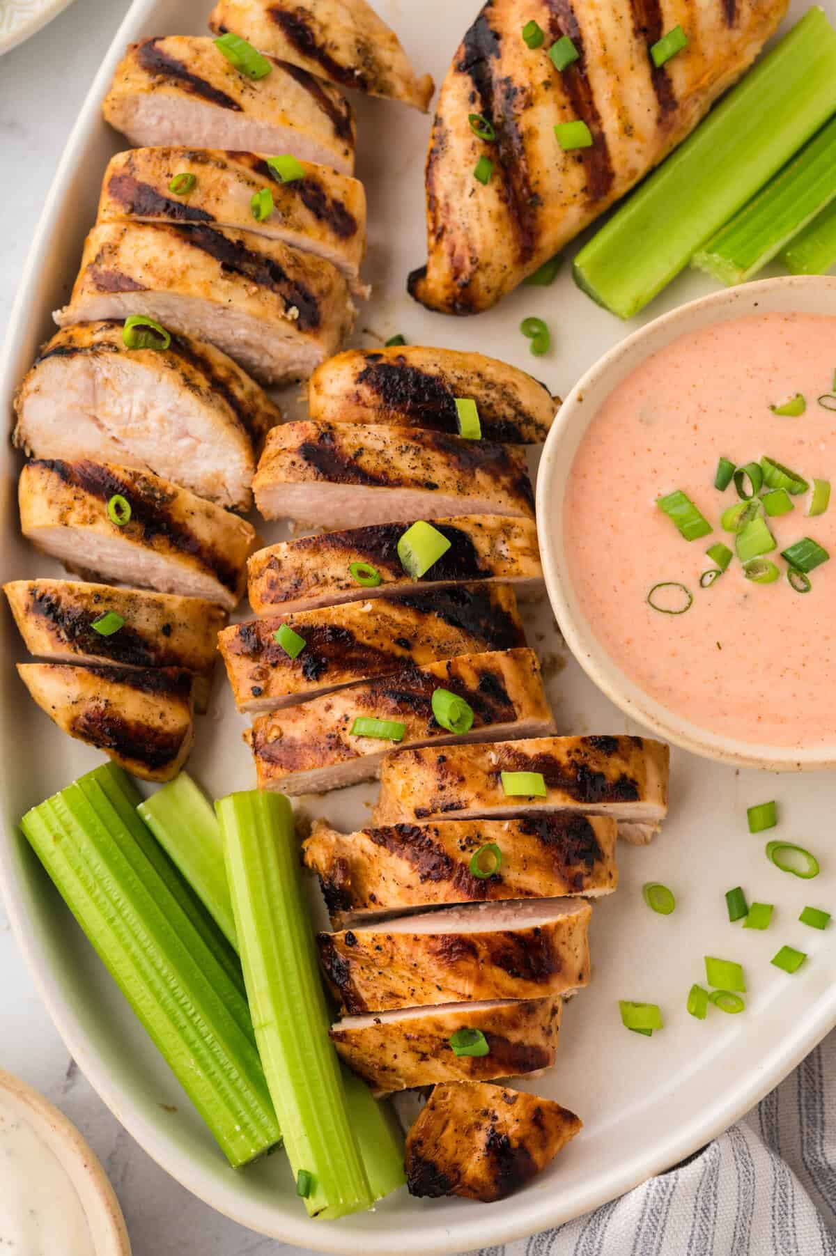 Buffalo ranch grilled chicken sliced on a white platter.
