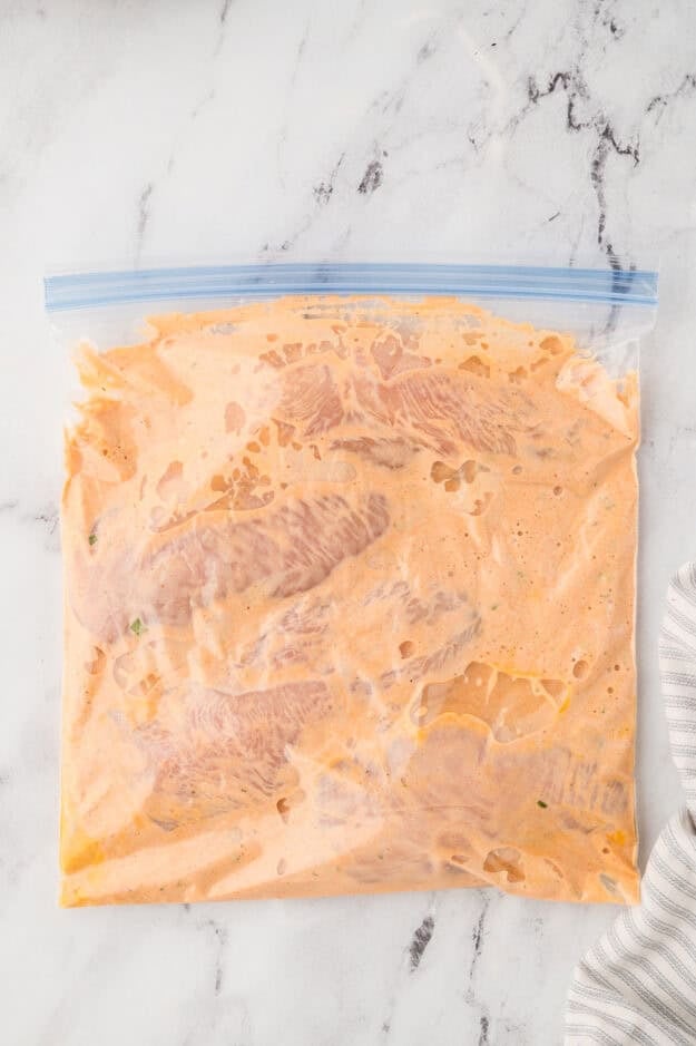 Chicken marinating in plastic bag.