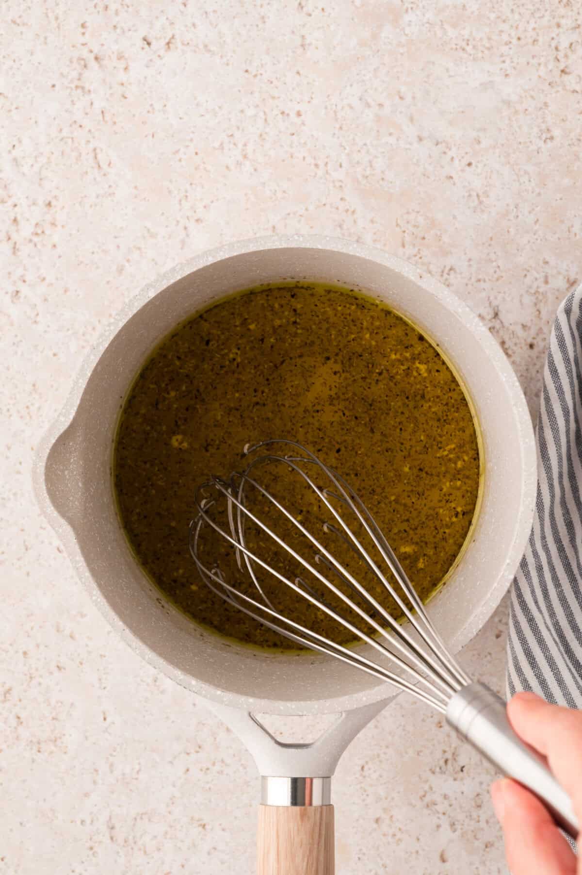 Dressing for vinegar coleslaw being whisked together in saucepan.