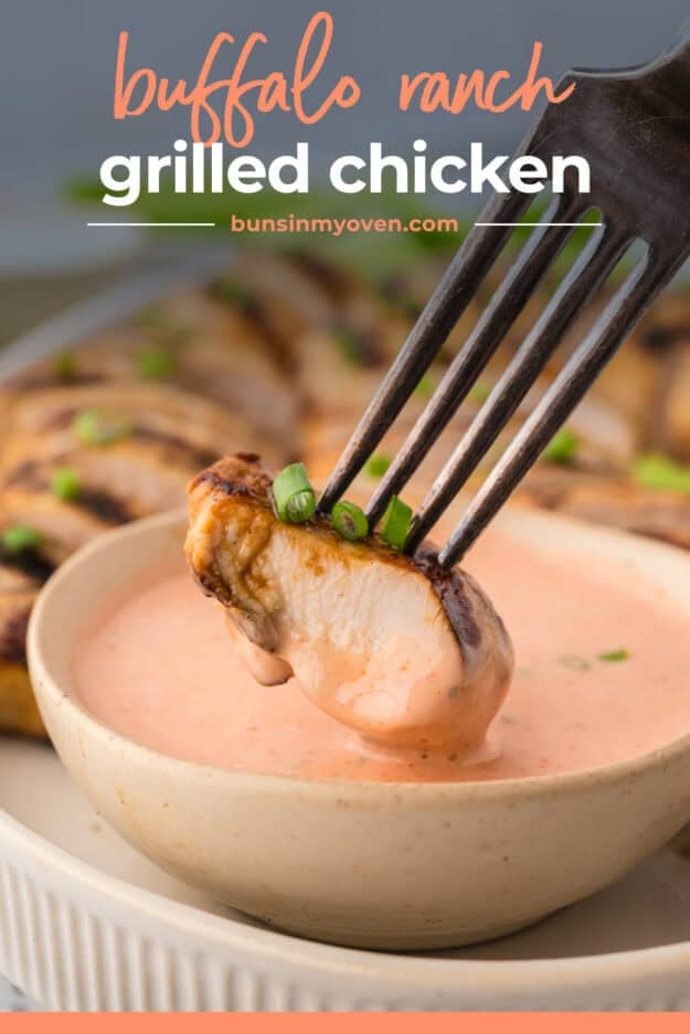 Piece of chicken being dipped in spicy ranch.