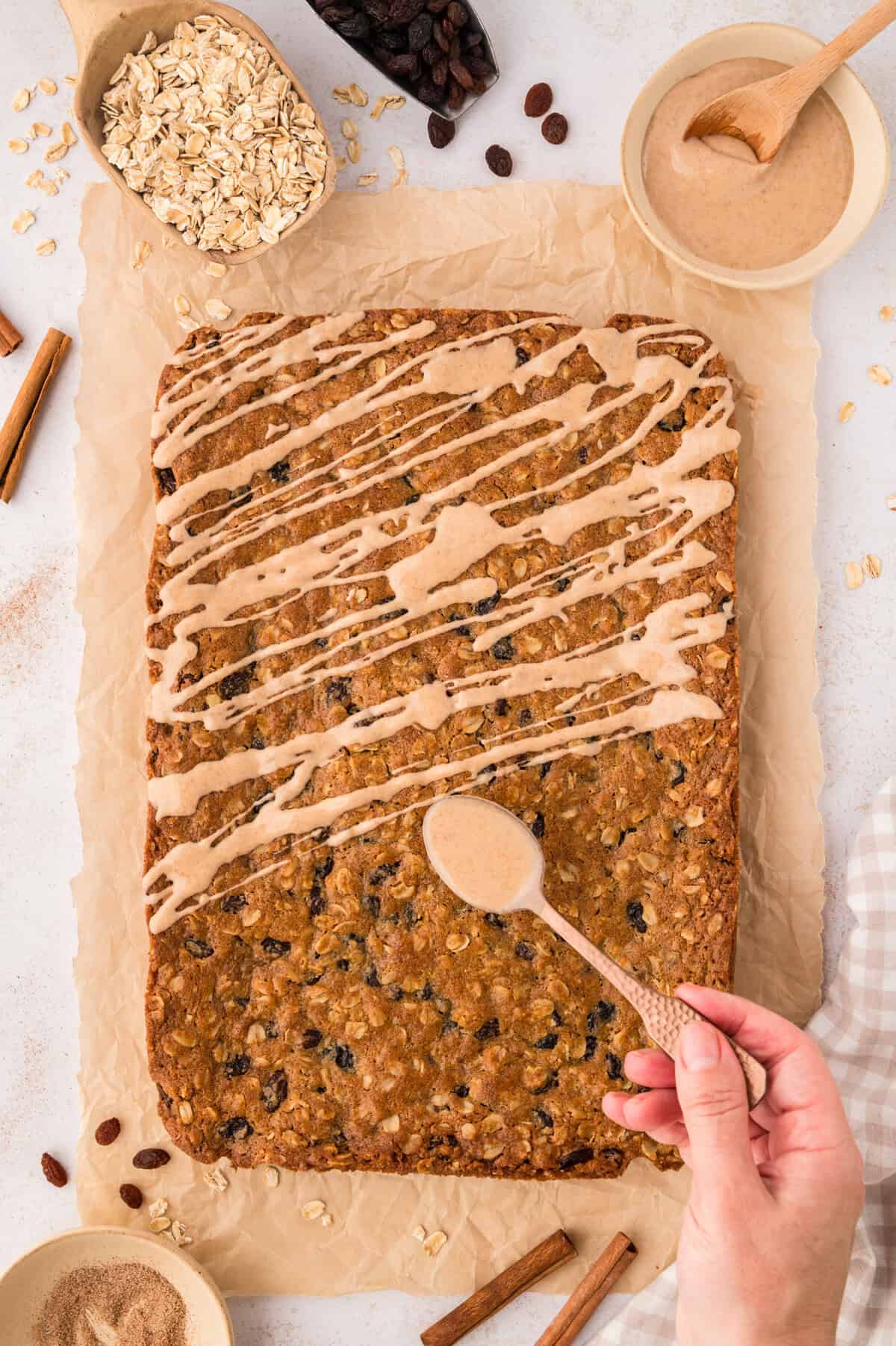 Glaze being drizzled over oatmeal cookie bars.