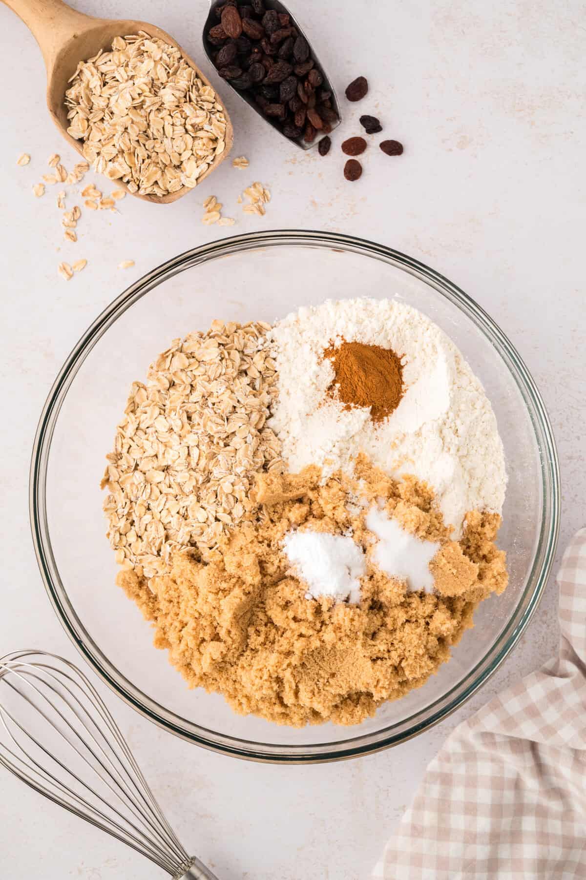 Dry ingredients for oatmeal raisin bars in glass bowl.