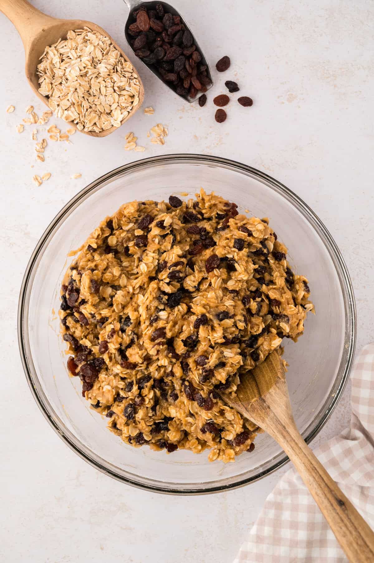 Oatmeal raisin bars dough in glas mixing bowl.