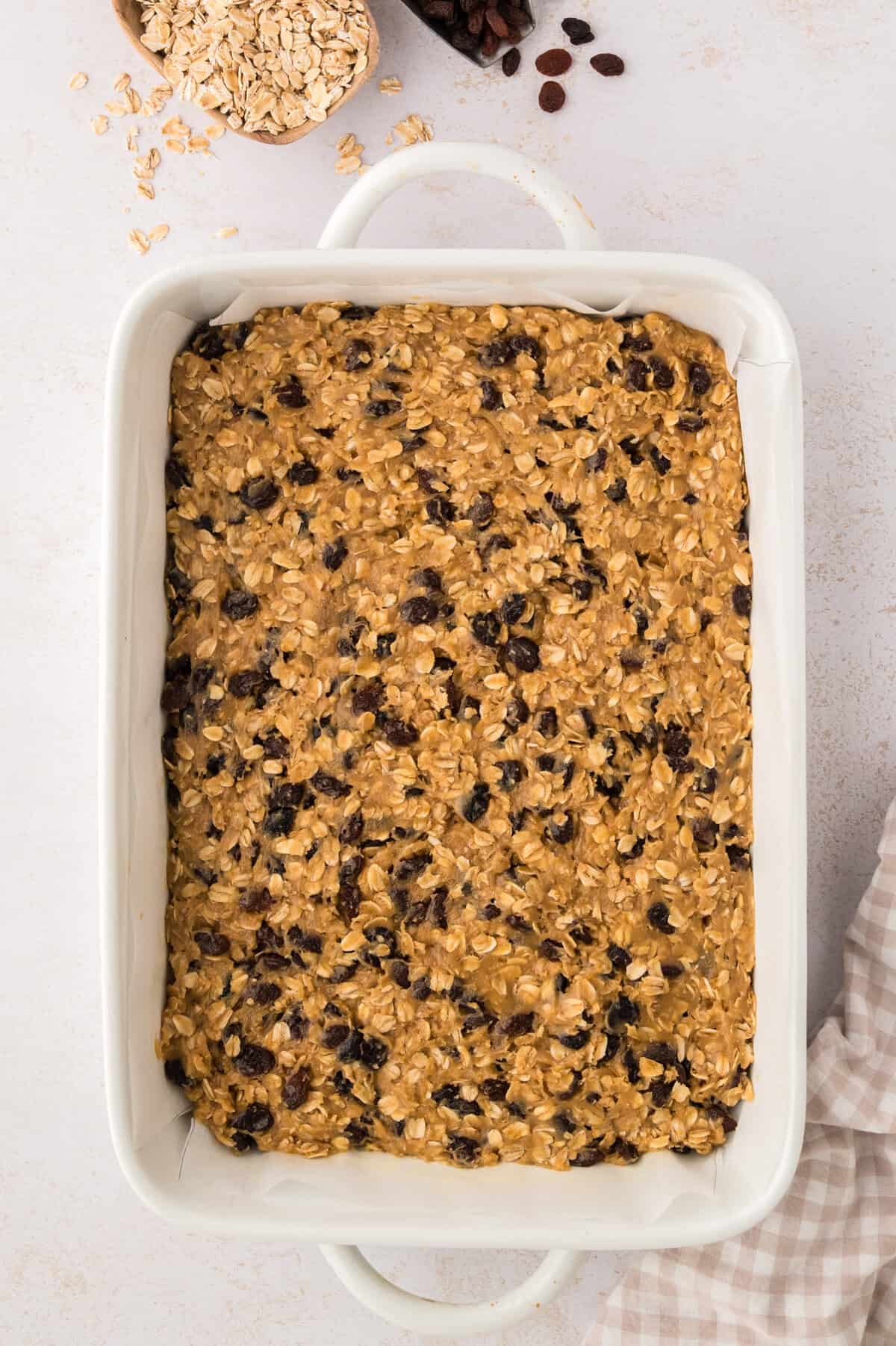 Oatmeal raisin bars in ceramic baking dish.