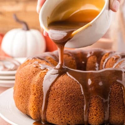 Brown sugar glaze being poured over pumpkin cake.