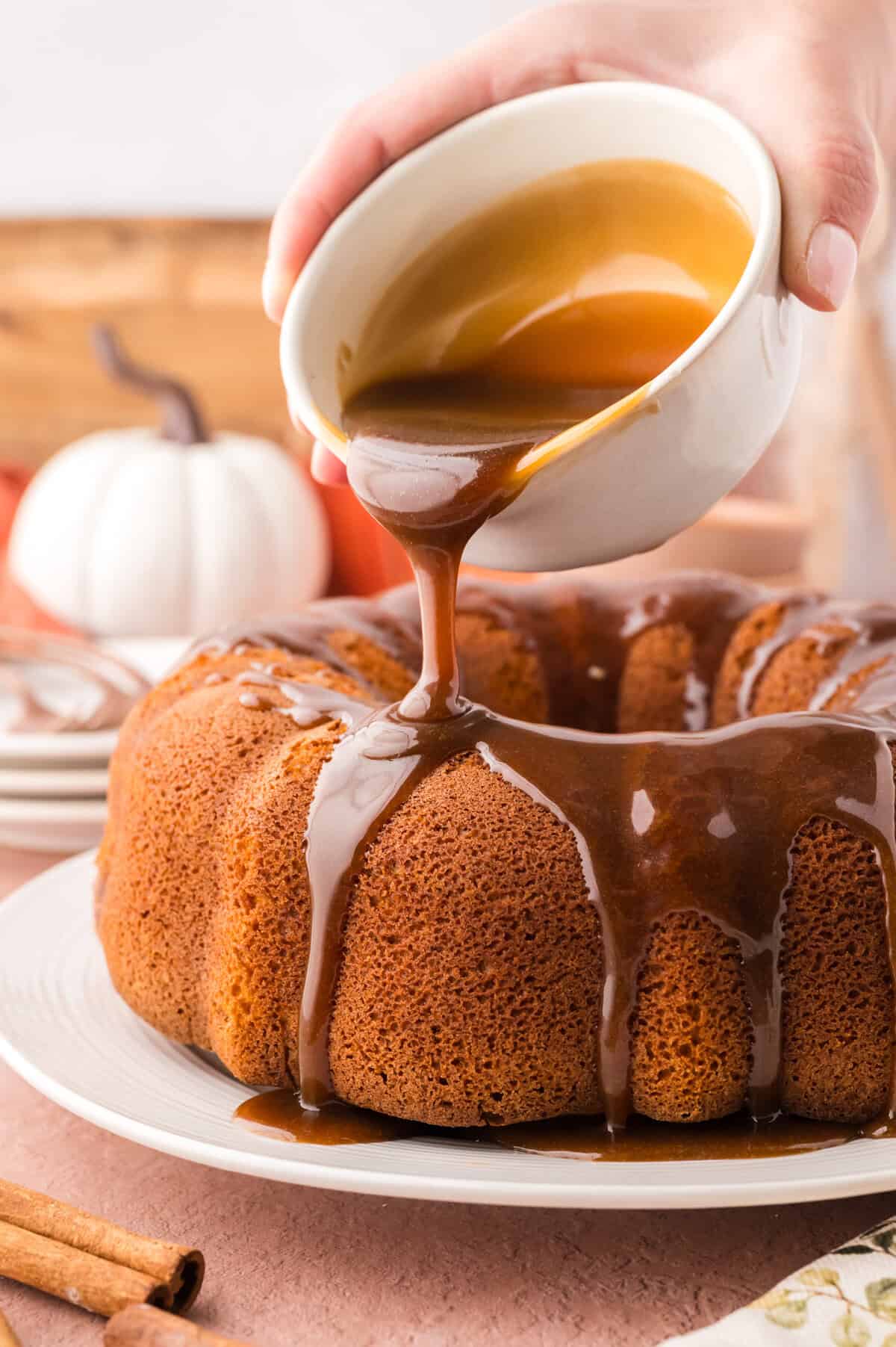 Brown sugar glaze being poured over pumpkin cake.