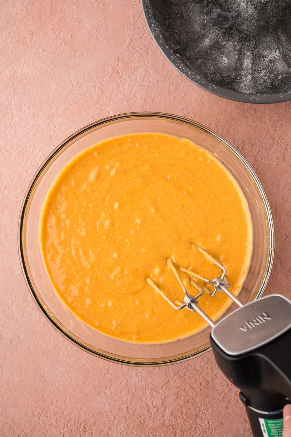 Ingredients for pumpkin cake batter in mixing bowl.