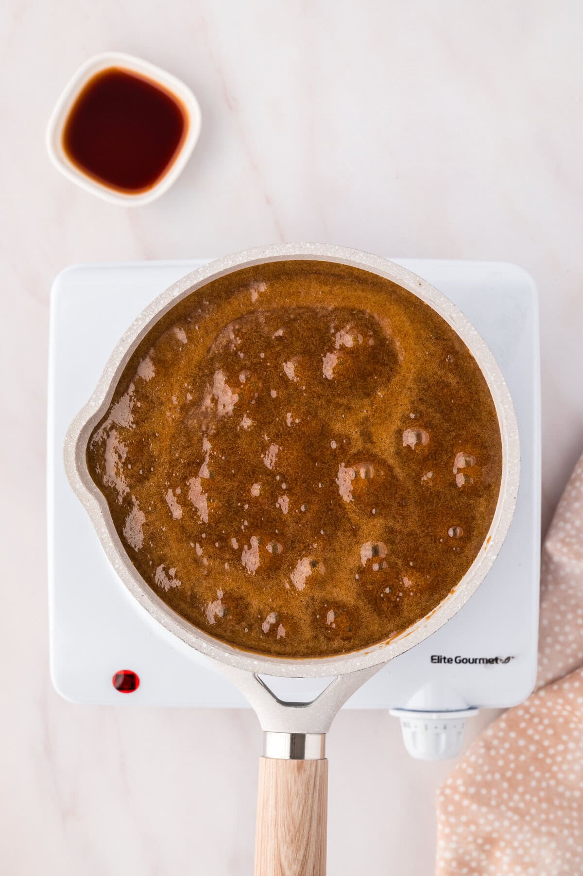 Butterscotch sauce boiling in saucepan.