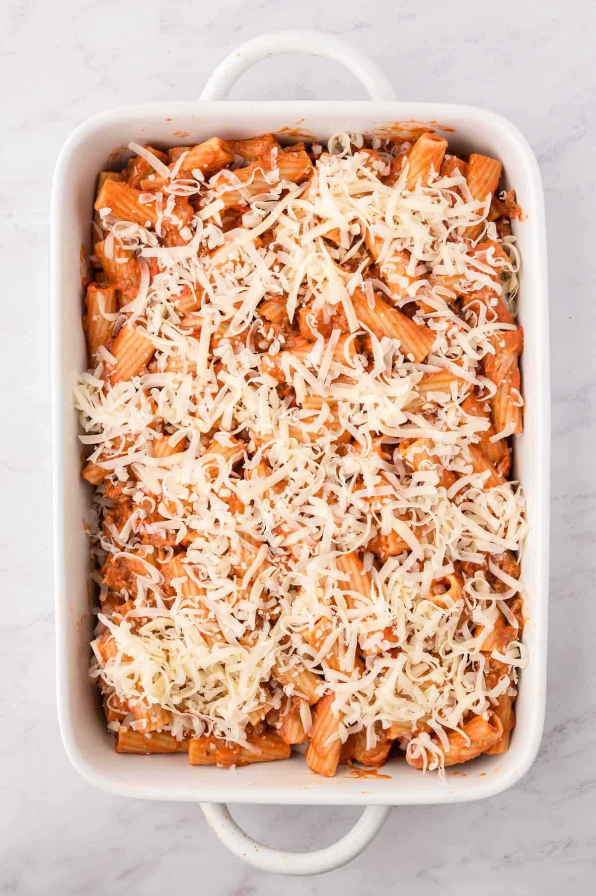 Cheese sprinkled over the top of rigatoni.
