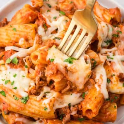 Fork in plate full of baked rigatoni.