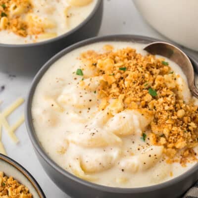 Bowl of mac and cheese soup topped with Ritz crackers.