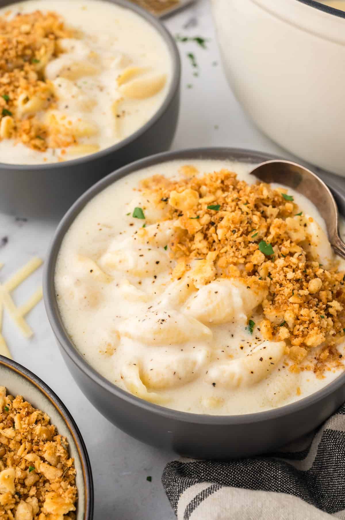 Bowl of mac and cheese soup topped with Ritz crackers.