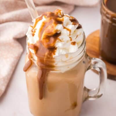 Butterscotch latte in glass jar with glass straw.