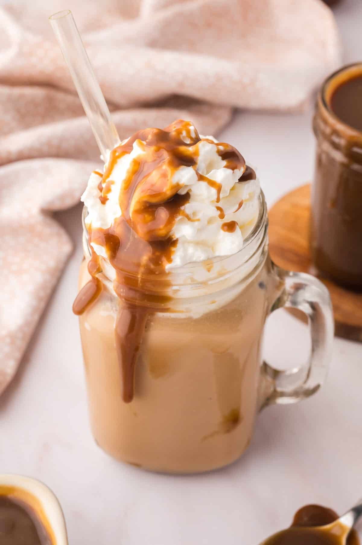 Butterscotch latte in glass jar with glass straw.