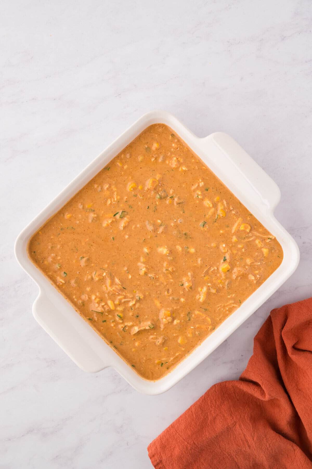 Enchilada dip in white baking dish ready for the oven.
