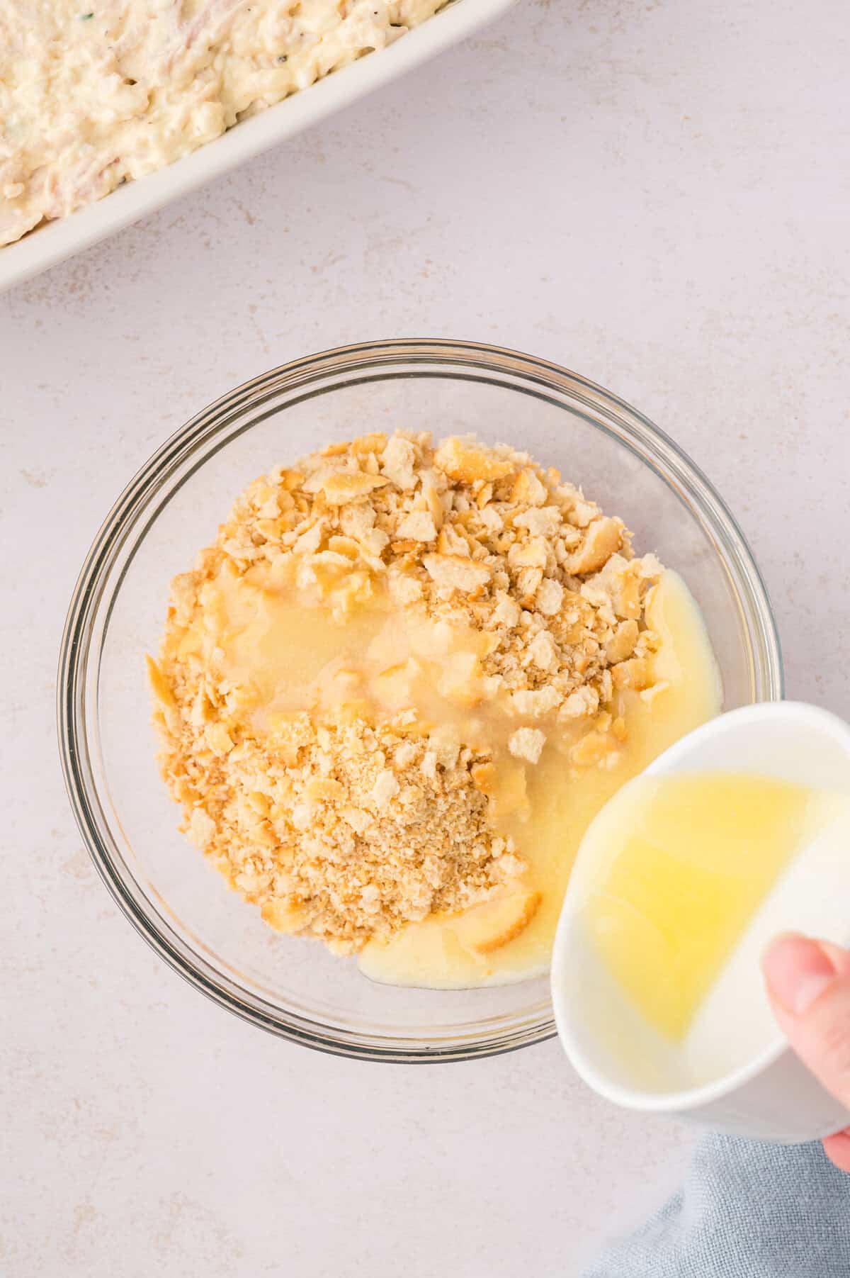 Cracker crumbs being mixed with butter.