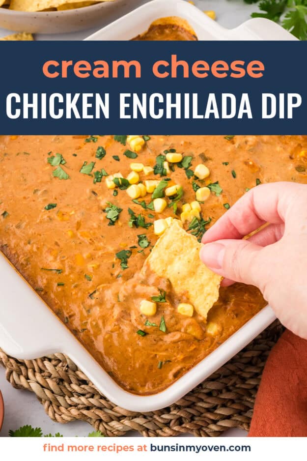 Hand dipping a chip into dish full of chicken enchilada dip.
